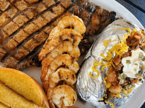 ribeye steak with grilled shrimp and loaded baked potato