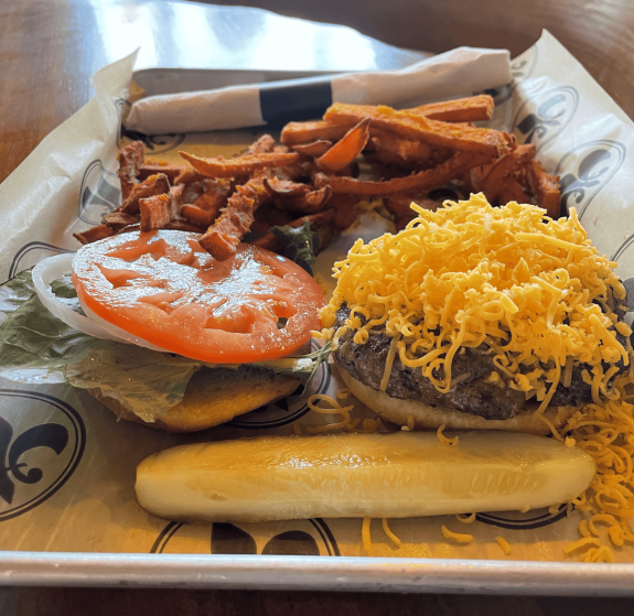 cheeseburger with shredded cheddar fries and pickle at restaurant